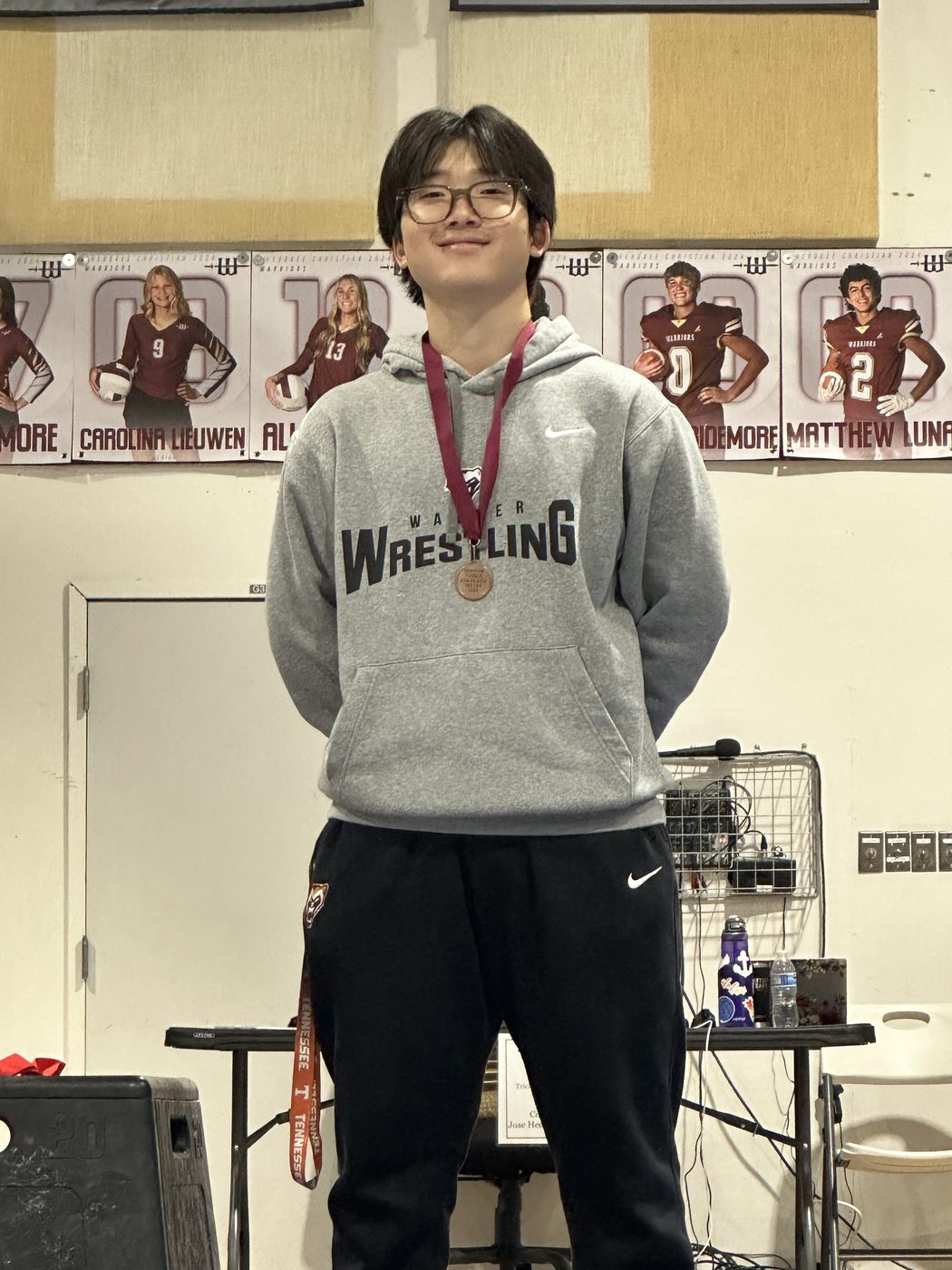 Yumin in a wrestling sweatshirt wearing a medal