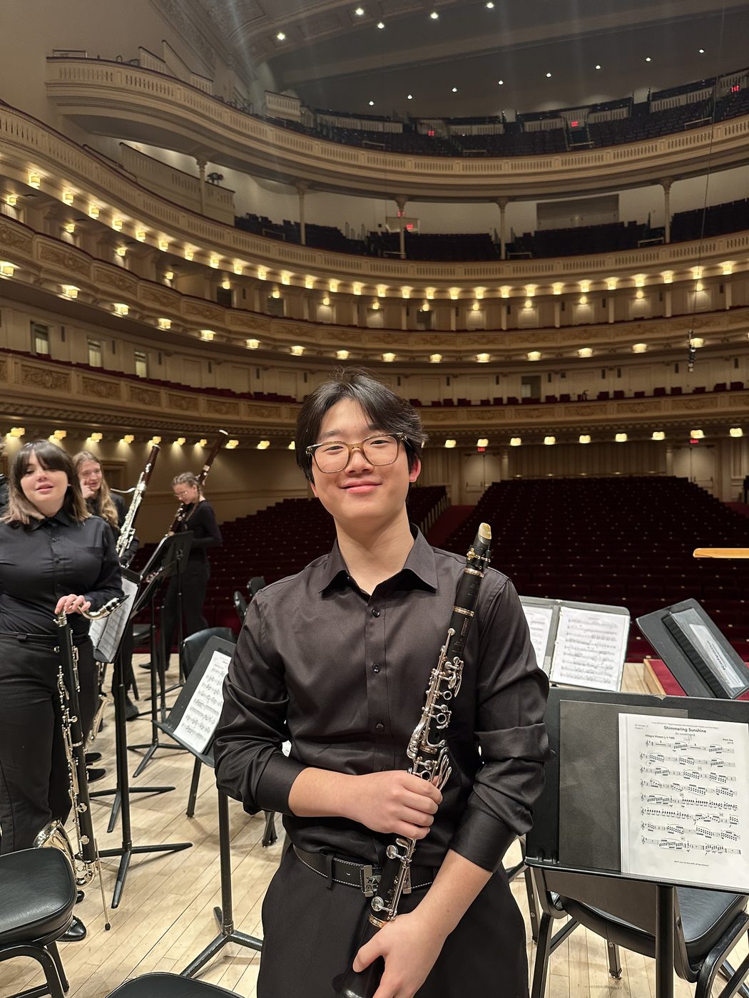 Yumin holding a clarinet on stage at Carnegie Hall