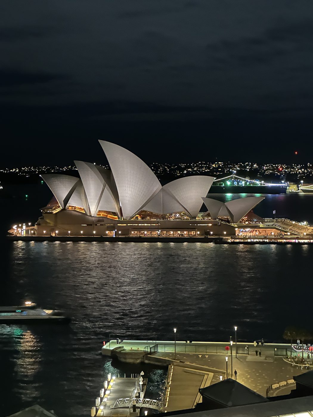 The Sydney Opera House at night across the harbor